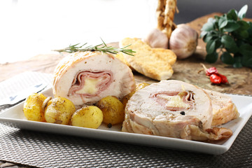 Roulade of stuffed chicken with potatoes and rosemary