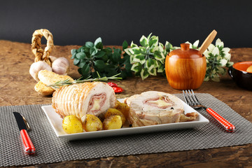 Roulade of stuffed chicken with potatoes and rosemary
