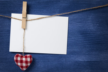 fabric heart and empty card on wooden background