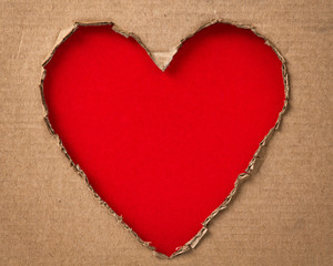 Naklejka na ściany i meble hole in a shape of heart on cardboard