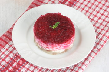 Traditional Russian salad with herring on a checkered napkin