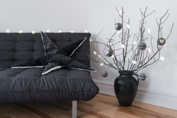 Gray sofa, winter decorations and cozy lights