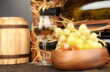 Wooden case with wine bottles, barrel, wineglass and grape
