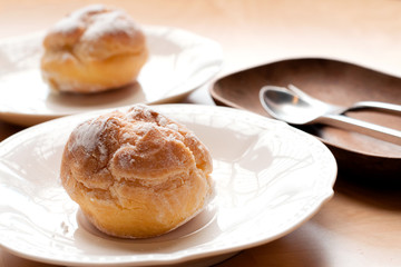 Choux pastry cream puffs on white plate
