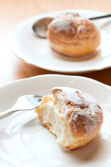 Choux pastry cream puffs on white plate