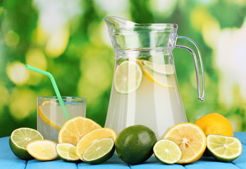 Citrus lemonade in pitcher and glass of citrus around