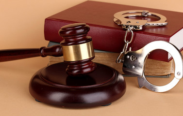 Gavel, handcuffs and.book on law on beige background