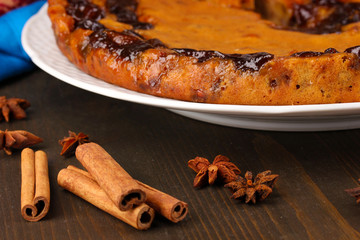Tasty pie on plate with cinnamon isolated on white