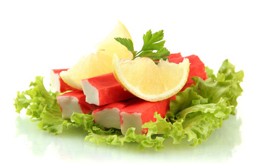 Crab sticks on lettuce leaves with lemon, isolated on white