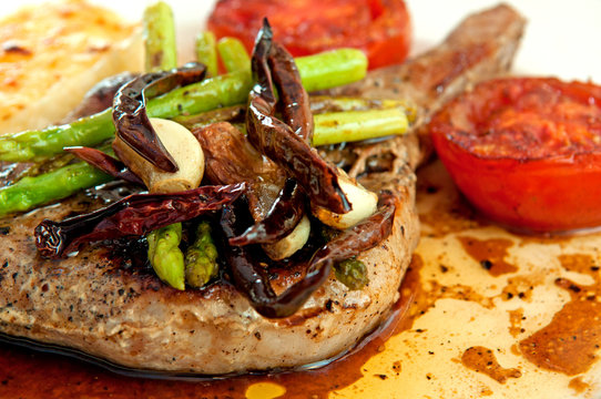 Grilled Pork Chop And Tomatoes With Potato Mash And Asparagus. H