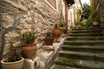 Fototapeta na wymiar Flower pots on narrow medieval street