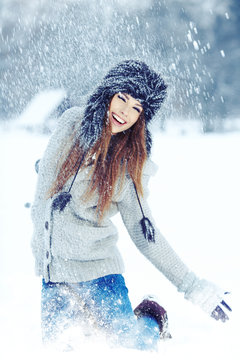 Girl playing with snow in park