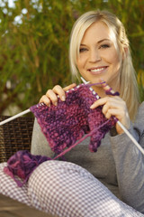 Hübsche Frau mit Strickzeug auf der Terrasse