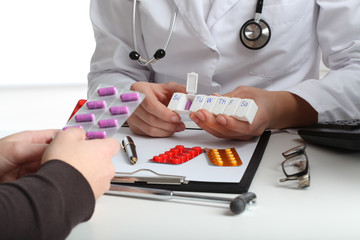 Doctor giving pills to patient