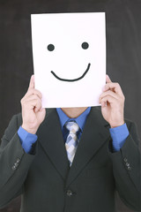 Young businessman hiding his face with a white billboard with a