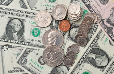 Dollar banknotes and coins as background.