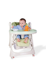 child is eating sitting at table, isolated over white