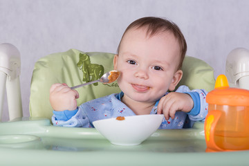 child is eating sitting at table, isolated over white