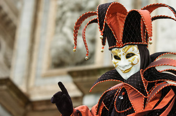 Person in Venetian costume attends the Carnival of Venice.