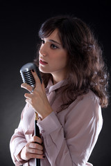Attractive young  woman with a retro microphone