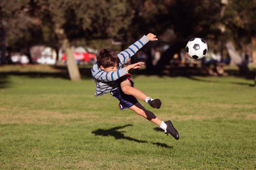 Boy kicking soccer ball