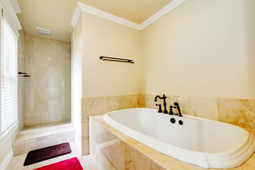 Nice empty bathroom with large white tub and shower.