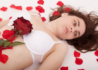 Obraz na płótnie Canvas Młoda kobieta otoczony płatkami róż