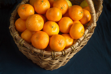 Many ripe oranges crop in brown wicker basket closeup