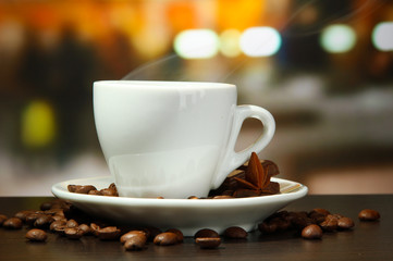 cup of coffee with beans on table in cafe
