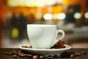 cup of coffee with beans on table in cafe