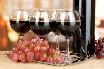 Red wine in glass and bottle on room background