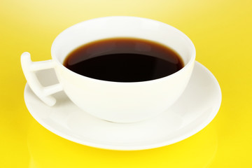 A cup of strong coffee on yellow background