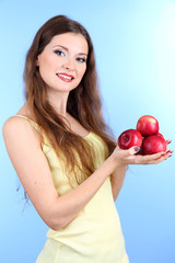 Beautiful woman with apples on blue background