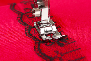 Closeup of sewing machine working part with  red cloth