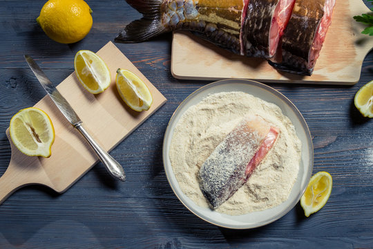 Fresh fish, flour and lemon as ingredients in a dish