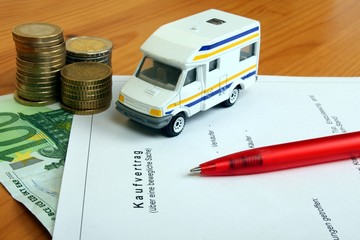 Kaufvertrag mit Kugelschreiber, Auto und Geld
