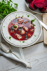 Borscht with dumplings served on an old farmhouse table