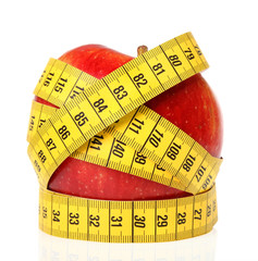 Measuring tape wrapped around a apple as a symbol of diet.