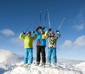 Drei Teenager mit Skistöcken nach oben