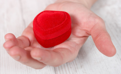 Red velvet jewelry box placed on palm