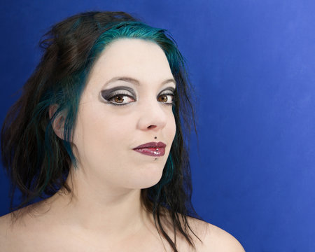 jeune femme mutine avec percings, smoky eyes et m&egrave;ches bleues