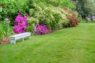 Landscaped garden scene with white bench