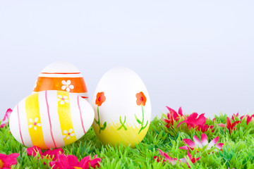 bemalte bunte Eier für Ostern auf Wiese mit Blüten