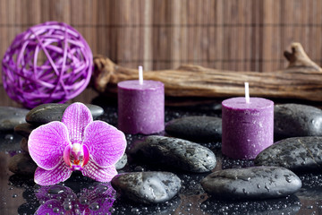 Obraz na płótnie Canvas Purple orchid candles and zen stones spa concept still life