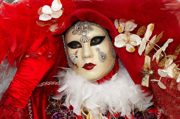 Person in Venetian costume attends Carnival of Venice.