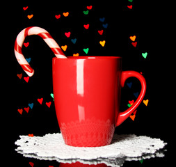 Obraz na płótnie Canvas Cup of coffee with holiday candy on Christmas lights background