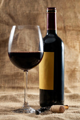 Botella de vino tinto y copa llena