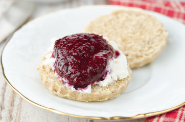 Scone with goat cheese and jam on a plate closeup