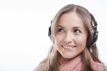 Fototapeta premium Cute woman listening to music and looking towards copy space