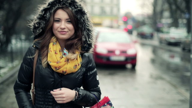 Happy young woman walking in the city, steadicam shot